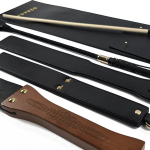 Deluxe BDSM Punisher Spanking Kit featuring impact play tools including a riding crop, spanking cane, leather paddle ruler, triple-layered spanking paddle, and a wooden-handle leather paddle, displayed with a black leather storage bag.