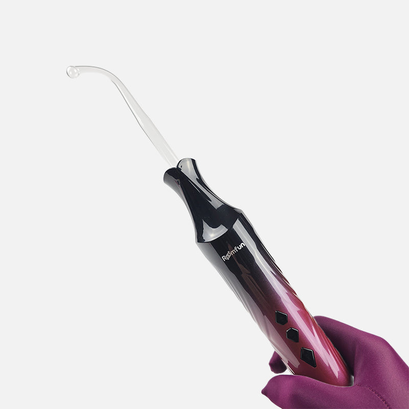 An electric whip and glass wand 2-in-1 interchangeable electro play e-stim set, featuring a metallic pink-to-black gradient handle with a long black tassel, shown on a light gray background with text at the top.