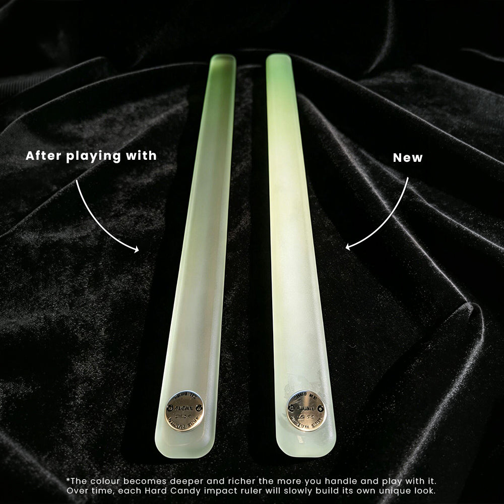Two frosted hard candy impact rulers, one labeled 'After playing with' and one labeled 'New', displayed on a black velvet background. The 'New' version is lighter and shows a pale green tint, while the 'After playing with' version is milky white.