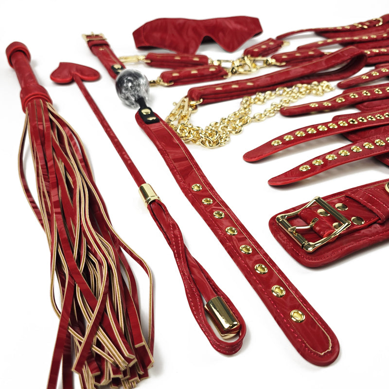 Red leather bondage set with gold accents on a white background. OZGAGA Deluxe Red Passion Velvet Bondage Restraint Spanking Kit (15pc)