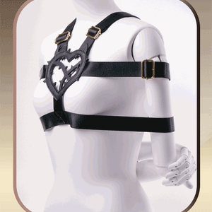 Person wearing a black harness with a heart-shaped design on a neutral background Takate Kote Bondage Harness with Thorn Love Heart