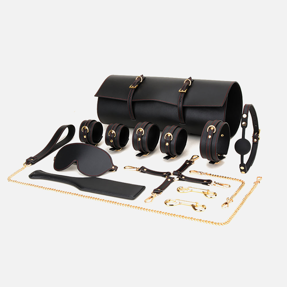 Collection of black leather bondage accessories on a white background